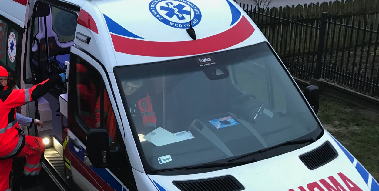 Kierowca transportu sanitarnego przy ambulansie